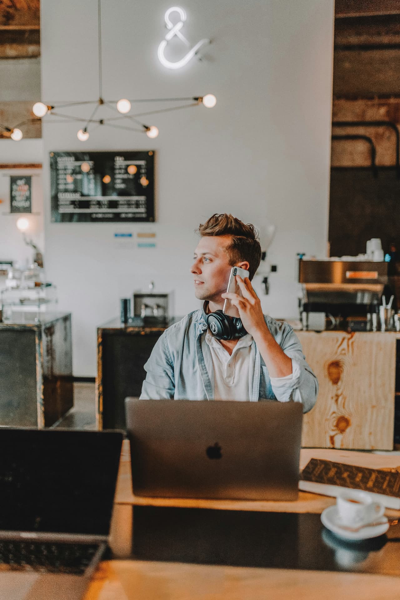 Konsult som talar i telefon vid sin laptop på ett kafé